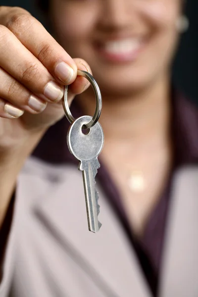 Business woman holding a key — Stock Photo, Image