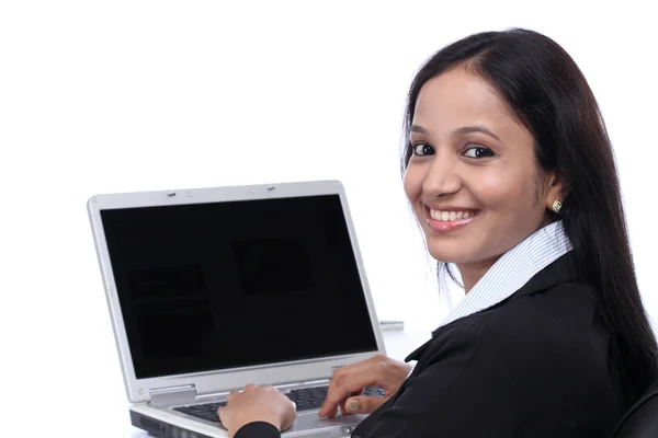 Gülümseyen genç iş kadını dizüstü bilgisayarla çalışıyor — Stok fotoğraf