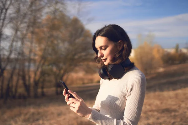 Parktaki akıllı telefondan gülümseyen kadın mesajları.