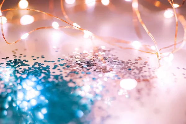 Pink and blue sparkles and lights on the pink background. Festive backdrop