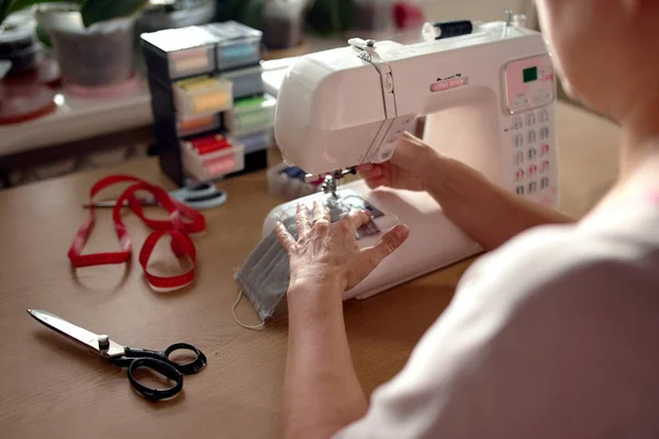 Жінка руками за допомогою швейної машини для шиття маски для обличчя — стокове фото