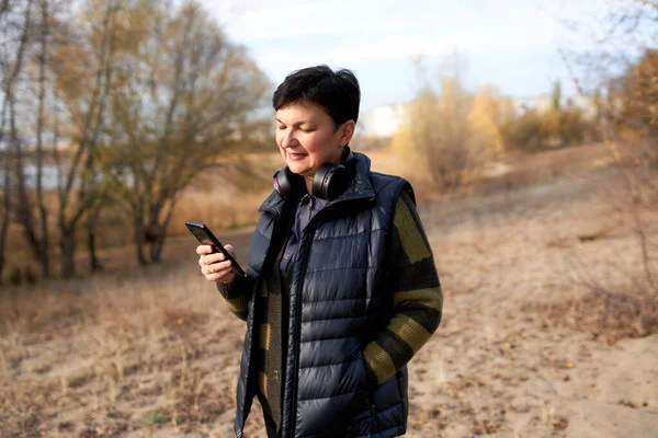 Happy Volwassen Vrouw Lopen Buiten Met Behulp Van Smartphone — Stockfoto