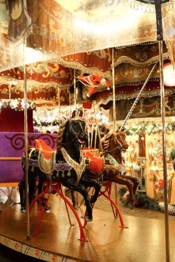 Festive carousel in a holiday park. Merry-go-round with horses.