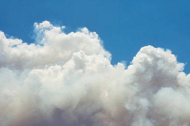Şiddetli yangından yükselen yoğun beyaz duman, dumanlı arka planı kapatır..