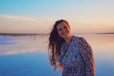 Okyanus kıyısında uçan kızıl saçlı güzel bir kadın.