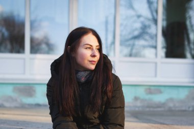 Siyah saçlı, gülümseyen güzel bir kadının portresi.