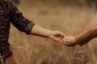 Güzel, şık bir çift Karpatlar 'ın dağ manzarasında el ele yürür..
