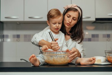 Anne ve oğlu evlerinin mutfağında elmalı turta yapıyorlar..