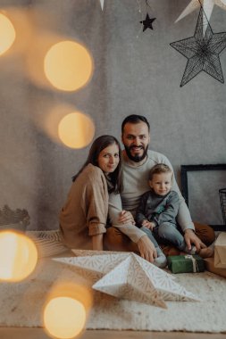 Genç, güzel bir anne ve baba Noel dekoru stüdyosunda eğleniyorlar..