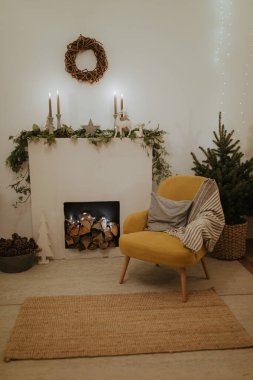 Noel ağacı ve şöminesi olan bir tasarım odası. İç mekan eko tarzı. Noel süslemeli kanepe ve Noel ağacı, modern ve rahat. Mutlu yıllar ve mutlu Noeller.