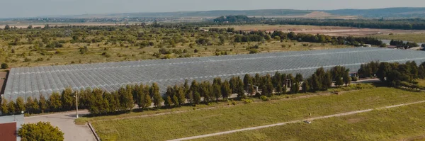 Aerial top view of greenhouse plant. Agronomy, year-round climate control and yield, indoor farming, heat recovery, power consumption and organic plant protection concept. Background image, copy space