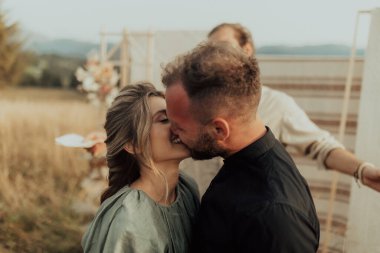 A young couple kissing and congratulating each other at the end of the wedding ceremony
