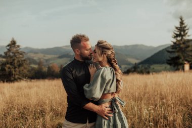 Beautiful and smiling young couple in love spend time in the mountains