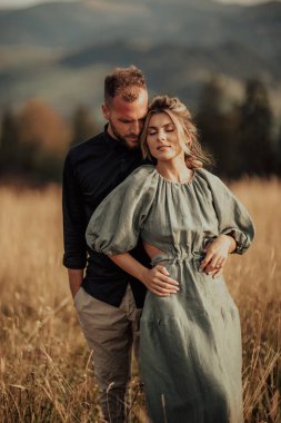 Beautiful and smiling young couple in love spend time in the mountains