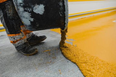 Epoksi ve poliüretan döşeme sistemi uygulayan işçiler. Bu kolay temizlenebilen ürünlerin de kaymayan özellikleri vardır..