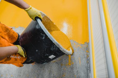 Epoksi ve poliüretan döşeme sistemi uygulayan işçiler. Bu kolay temizlenebilen ürünlerin de kaymayan özellikleri vardır..