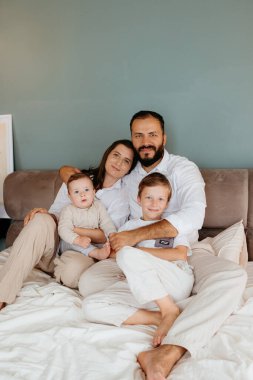 Dört çocuklu bir aile, büyük bir oğul ve küçük bir çocuk birlikte evde eğleniyorlar.