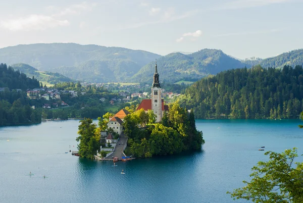 Igreja cristã na ilha, lago e montanhas fundo em Bled, Eslovênia Imagem De Stock