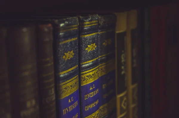 Sokak lambasının ışığıyla aydınlatılmış eski kitaplarla dolu bir kitaplık..