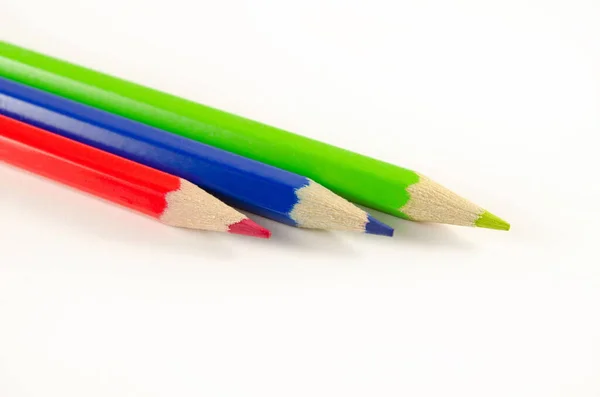 Beyaz zemin üzerinde üç kalem (mavi, kırmızı ve yeşil).