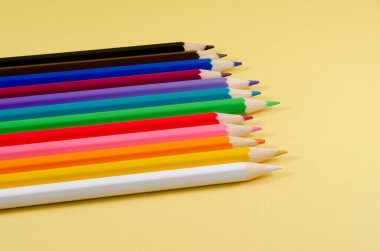 Sarı arka planda renkli kalemler..