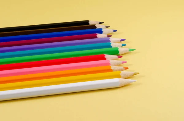 Sarı arka planda renkli kalemler..