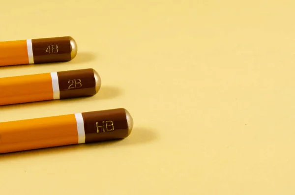 Sarı arka planda sertleştirilmiş keskin kalemler..