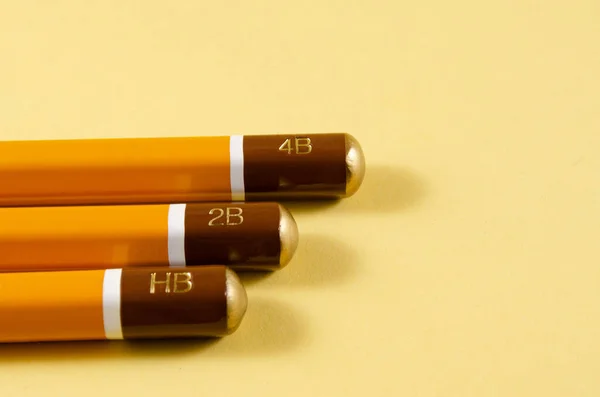 Sarı arka planda sertleştirilmiş keskin kalemler..