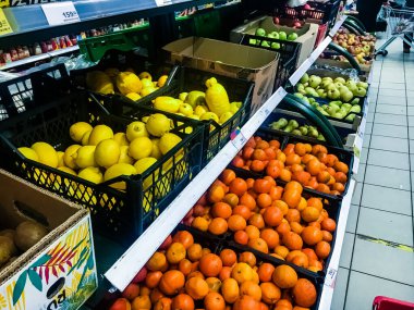 Süpermarkette meyve rafı. Kutularda portakal, elma ve limon var. Kimse.
