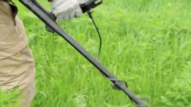 Bir adam elinde bir cihaz tutuyor, elinde bir metal dedektör, bir çayırda çalışıyor, bir tarlada, hazine, sikke, sanat eseri arıyor. Rusya, Vladimir, 26 Haziran 2021