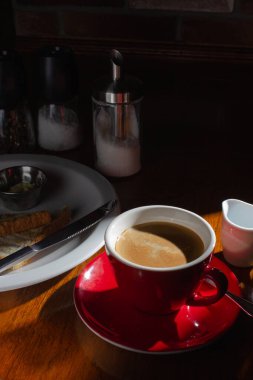 Sert ışıkta sütlü kahve ve tost.