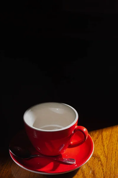 Tahta masaya boş kırmızı bardak.