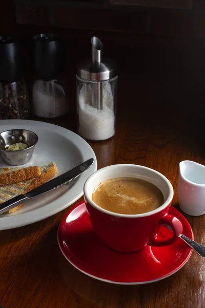 Sütlü kahve ve yumuşak ışıkta kızarmış ekmek.