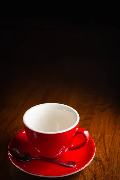 Ahşap masada boş kırmızı bardak.