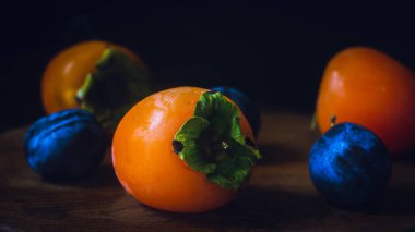 Parlak hurma ve mavi erikler yakın sehpanın üzerinde.