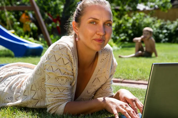 Junge schöne Mutter arbeitet als Freiberuflerin zu Hause — Stockfoto