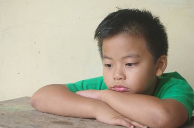 Masadaki yalnız çocuk negatif çocuk hissi. Yalnızlık. Çocuk üzgün.