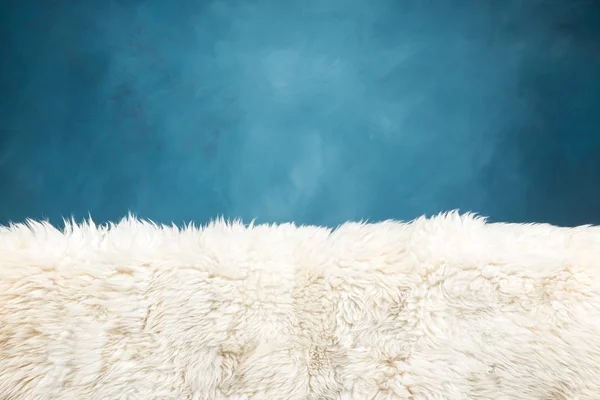 Weißer Fellteppich und blau bemalte Wand — Stockfoto