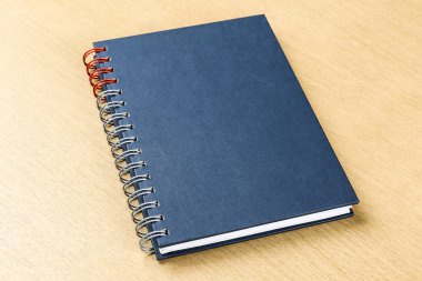 ahşap masa üstünde koyu mavi defter