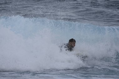 Büyük bir dalgayla denizde sörfçü
