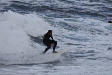Denizdeki bir dalgada sörfçü