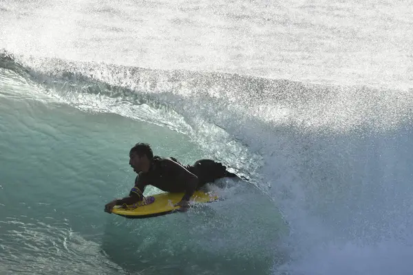 Okyanus dalgasında sörfçü