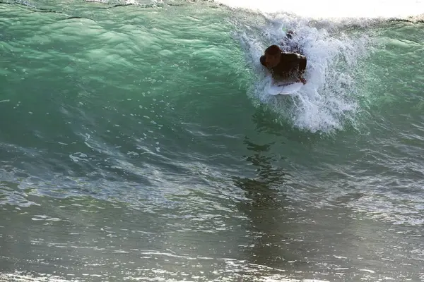 man riding a wave on the beach