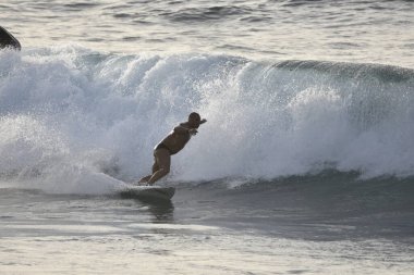 Deniz dalgalarında sörfçü