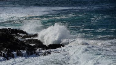 okyanus dalgaları kayalık kıyıya çöküyor