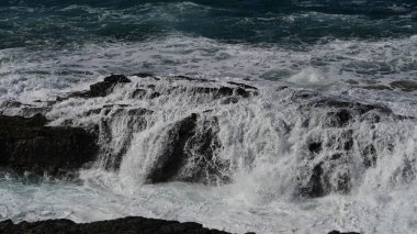 Okyanus dalgaları kayalara çarpıyor.
