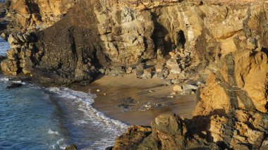 Okyanustaki kayalık plajının arka planda bir uçurumun dikey görüntüsü.