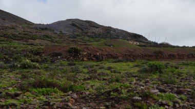 Bulutlu gökyüzü ile kayalık bir dağın güzel manzarası