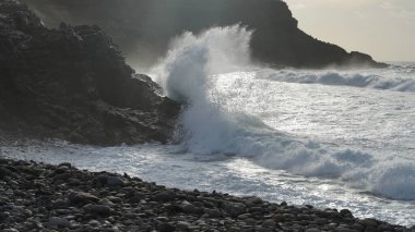 Büyük dalga kayaya çarpıyor.