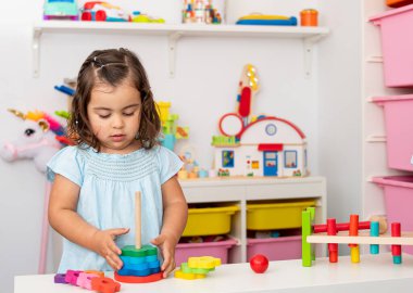 Kafkas kökenli, iki yaşında bir kız çocuğu. Anaokulundaki eğitici tahta oyuncaklarla oynuyor ve öğreniyor..